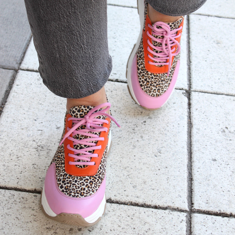 ett par skor i rosa, orange och leopardmönster. The Shoe Bakery