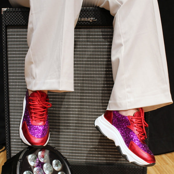 Glittriga sneakers i cerise och röd. Vita byxor. The Shoe Bakery