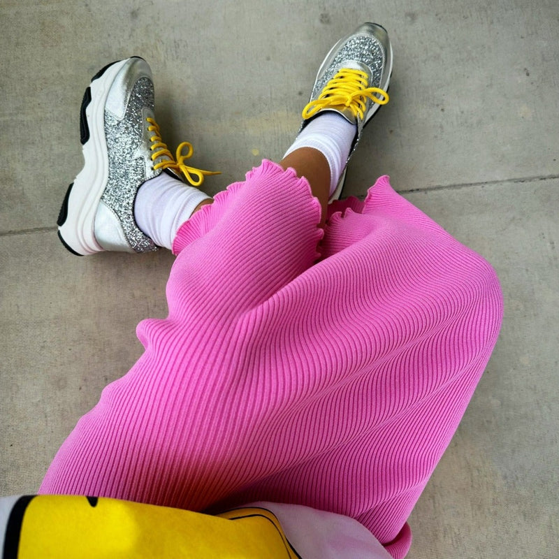 Hanna Happy i ett par Silver Sneakers. Rosa stickad kjol. Glitterskor. The Shoe Bakery