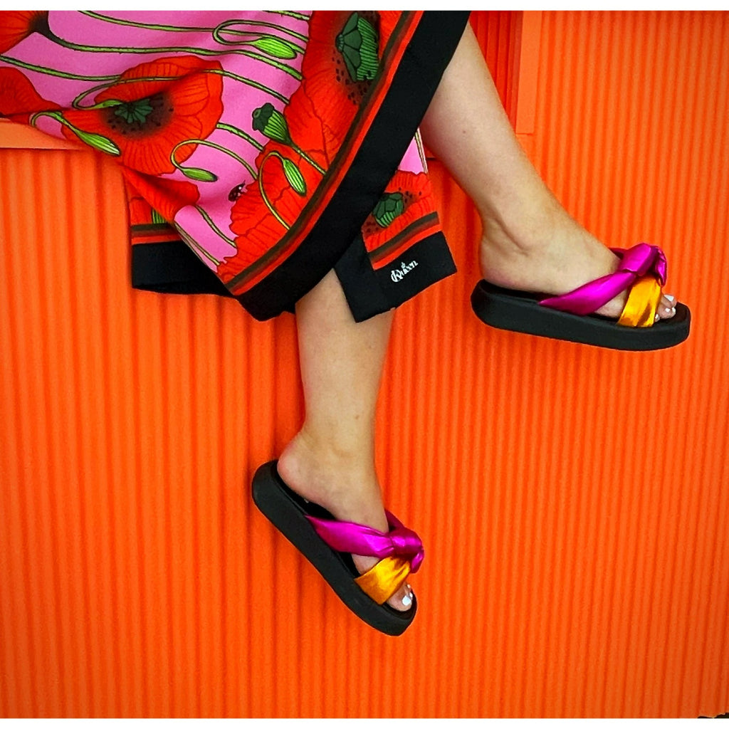 Ett par fötter men sandaler. Slip in Sandal rosa och orange. Rosa och orange sko. The Shoe Bakery