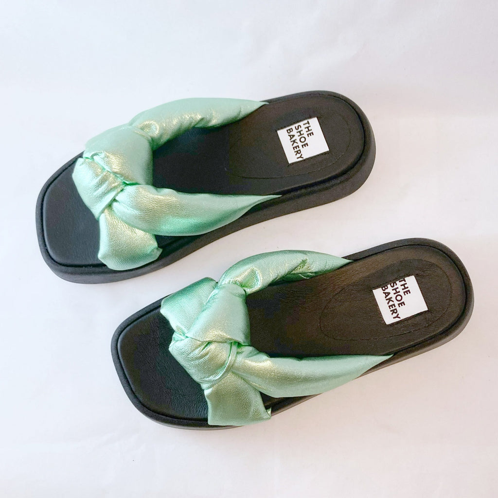 Ett par gröna sandaler med svart sula. Slipin sko. The Shoe Bakery