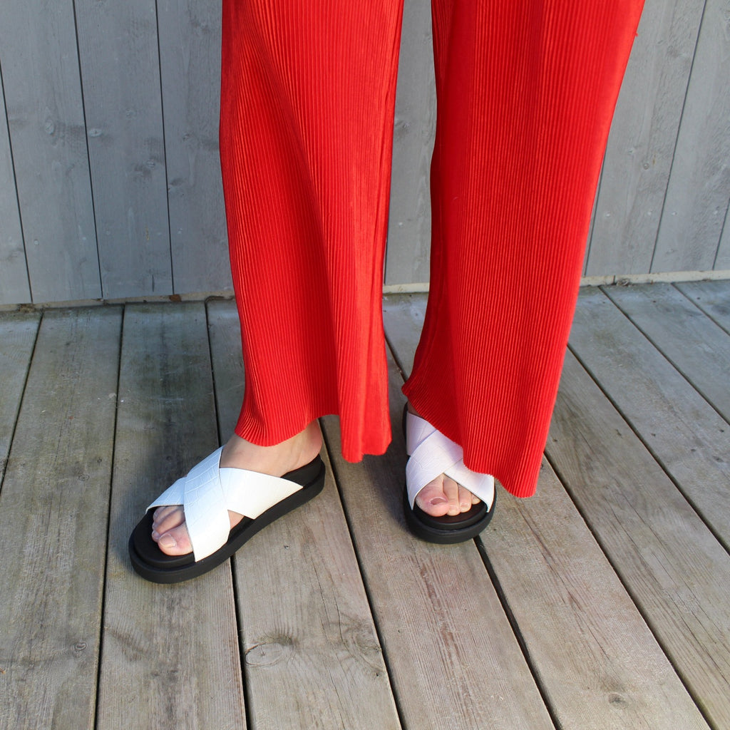 en bild på en person med röda byxor och vita sandaler. The Shoe Bakery