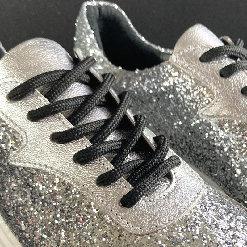 en närbild på svarta skosnören som sitter på en glittrig silversko The Shoe Bakery